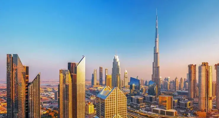Skyline di Dubai al tramonto con il Burj Khalifa e grattacieli dorati, simbolo del sogno venduto dai fuffaguru