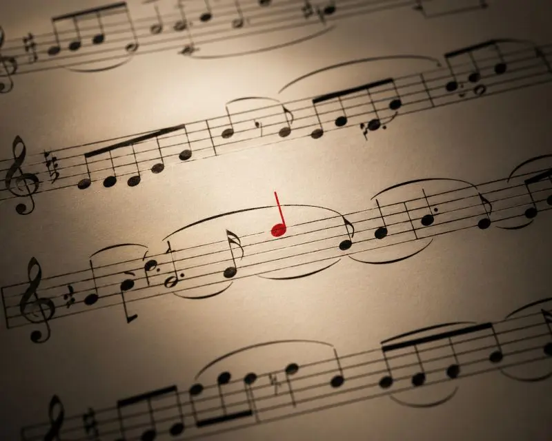 Uno spartito musicale con una nota rossa che si distingue dalle altre